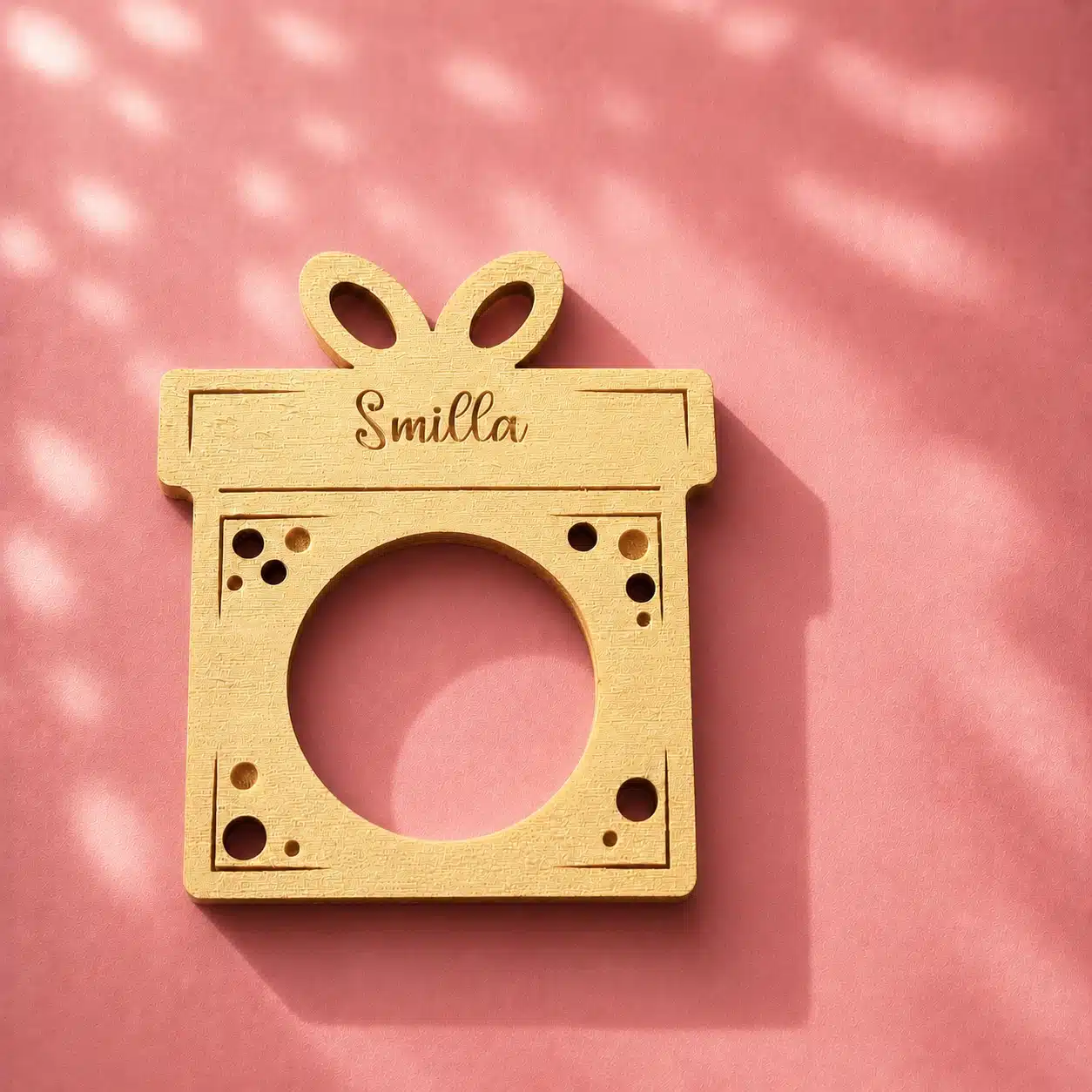 Serviettenring aus Holz mit Namen auf rosa Hintergrund