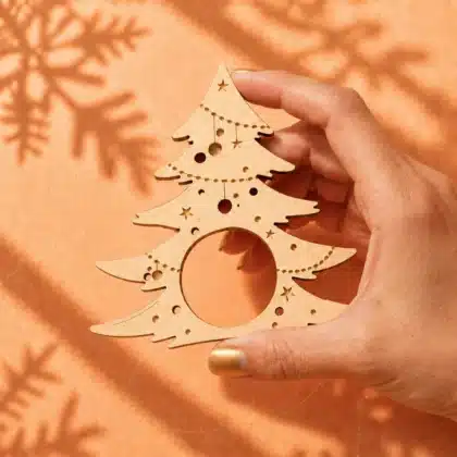 Serviettenhalter Vintergrön in Frauenhand auf warmem Hintergrund mit Flockenschatten