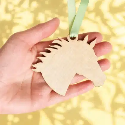 Medaille Pferd aus Holz in der Hand